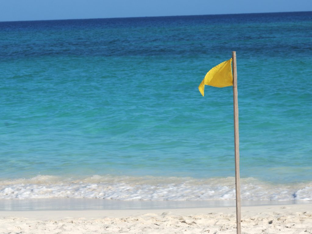 Yellow flag on the beach in Los Cabos. Safe to swim.