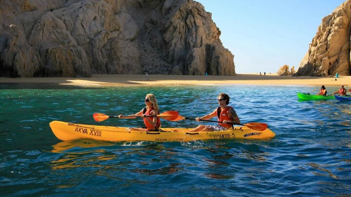Couple kayak in from of Lover's Beach
