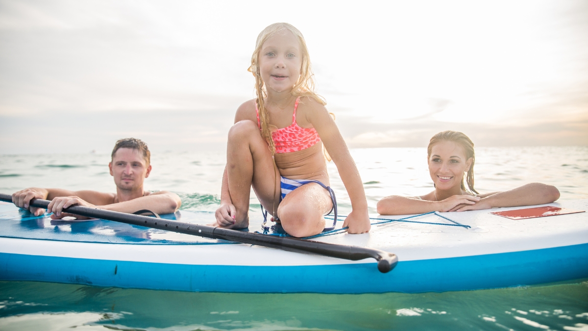 Family paddleboarding to Lover Beach in Cabo Bay